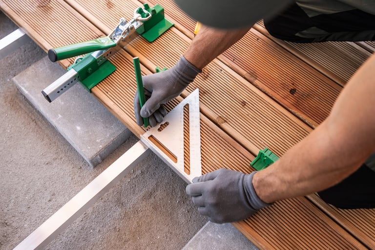 Craftsman placing square tool on wooden planks during deck renovation